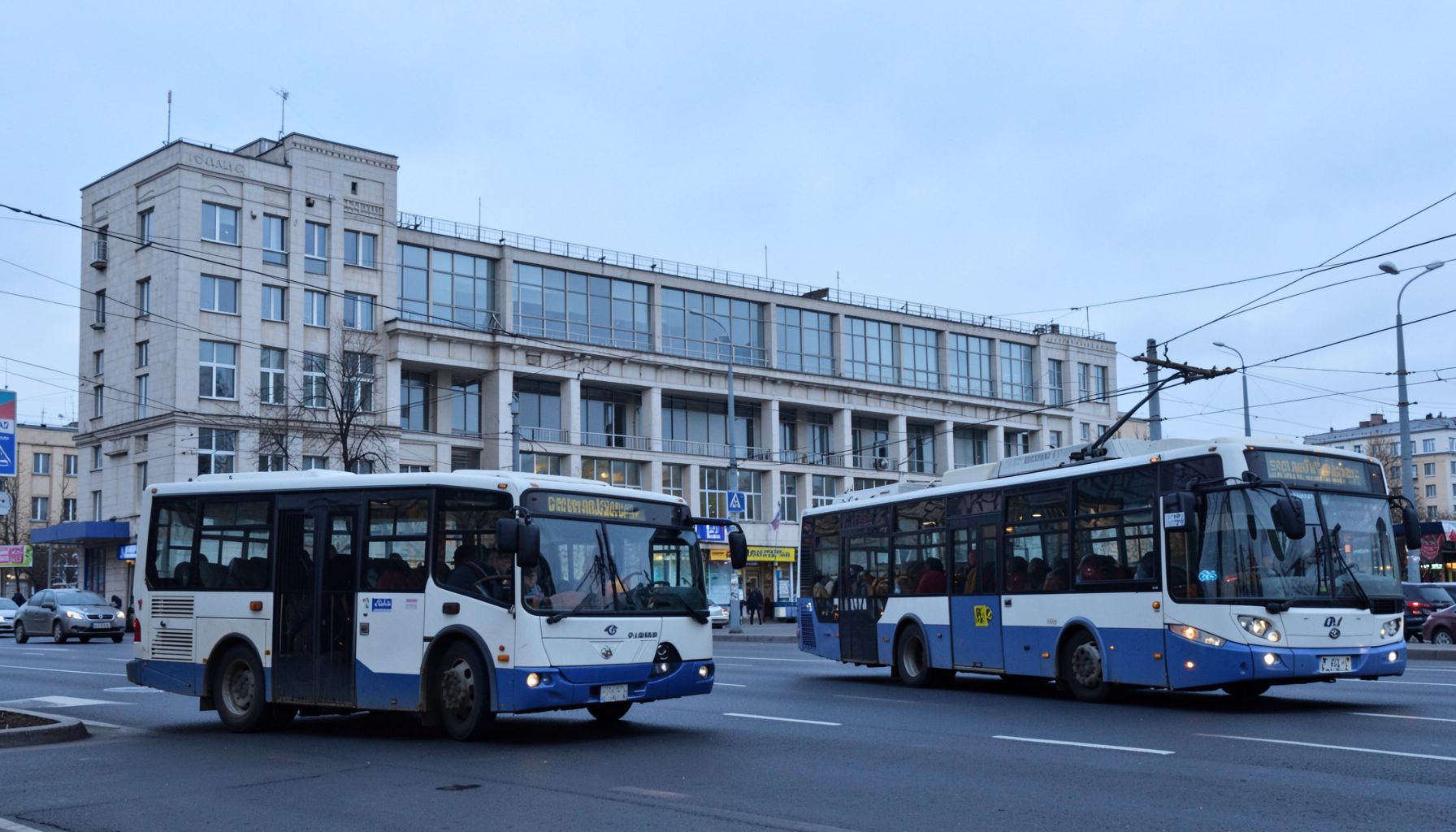 Городской автобус и троллейбус на фоне здания автовокзала в Сумах, спокойные серо-голубые тона, дневное освещение